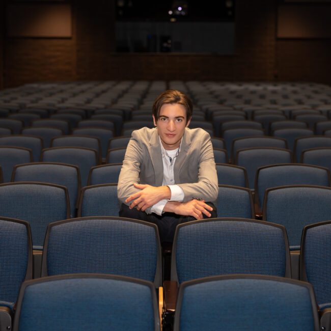 Senior guy sitting alone in the seats of an empty theater